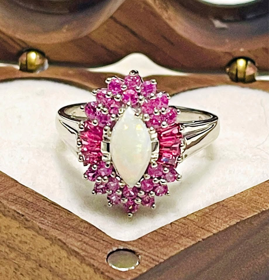Close-up of a stunning ring featuring a marquise Australian opal surrounded by a vibrant pink sapphire halo.