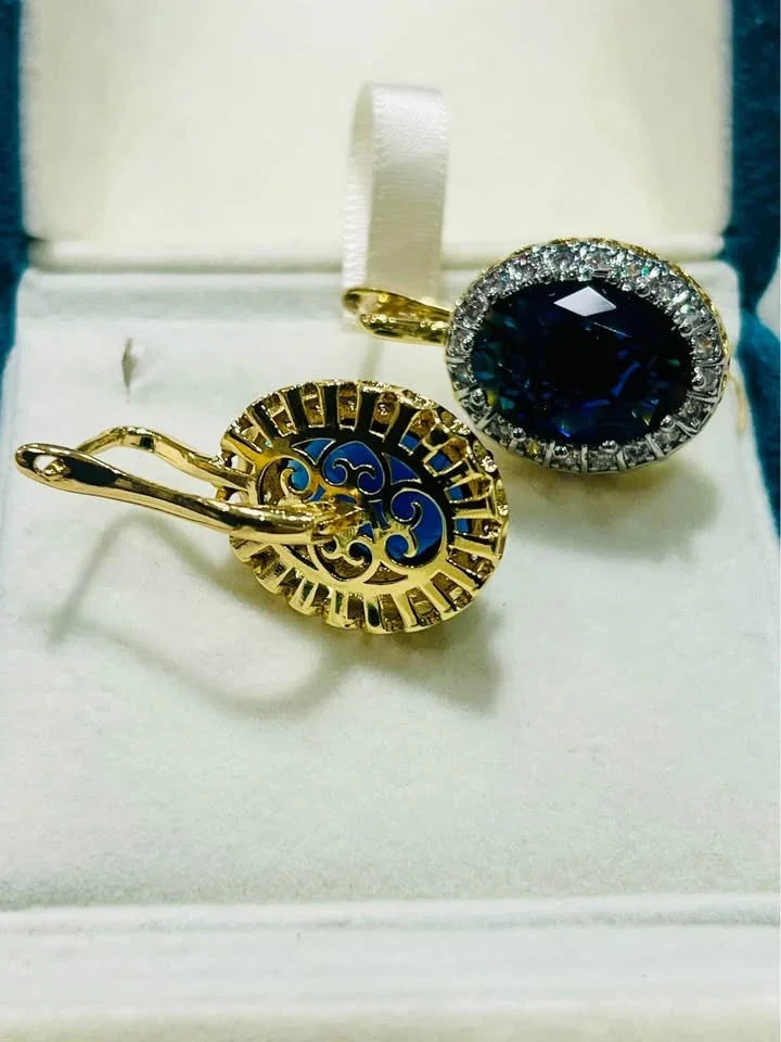View of the intricate scrollwork on the back of 18k gold vermeil and blue sapphire earrings.