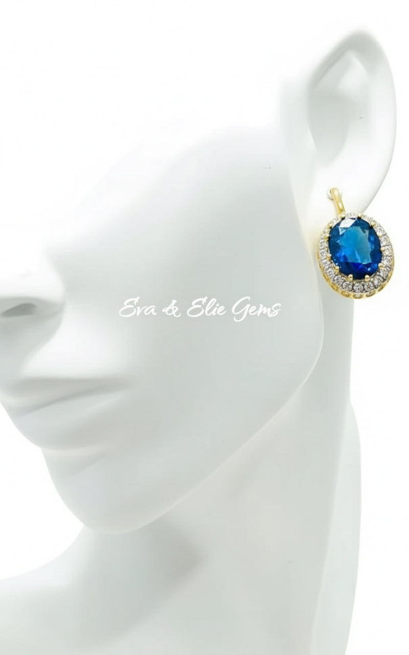 Blue sapphire halo earrings on a mannequin, highlighting the rich color and 18k gold vermeil finish.