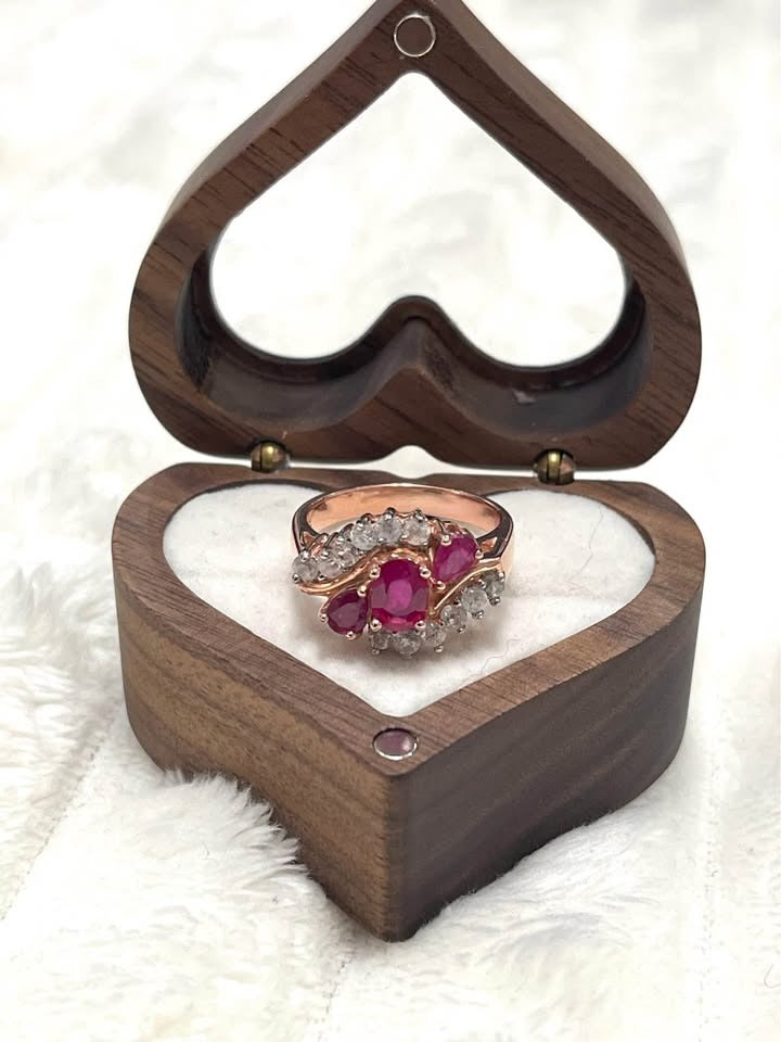 A stunning 18K rose gold plated sterling silver ring with natural Burmese rubies, displayed in a wooden heart box.