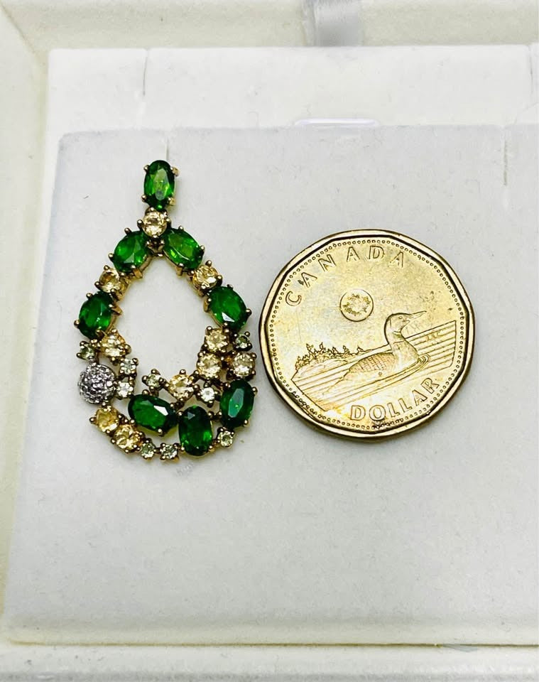 Single handmade chrome diopside and sapphire earring next to a Canadian dollar for size comparison.