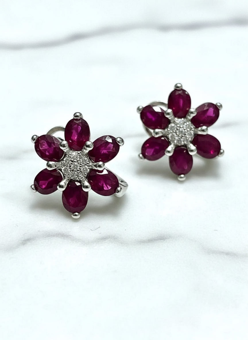 Close-up of natural ruby and white sapphire flower earrings, showcasing intricate detail.