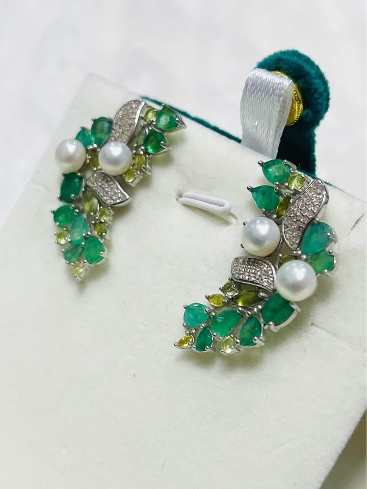 Silver earrings with Colombian emeralds, green sapphires, and pearls in a unique leaf-inspired design.
