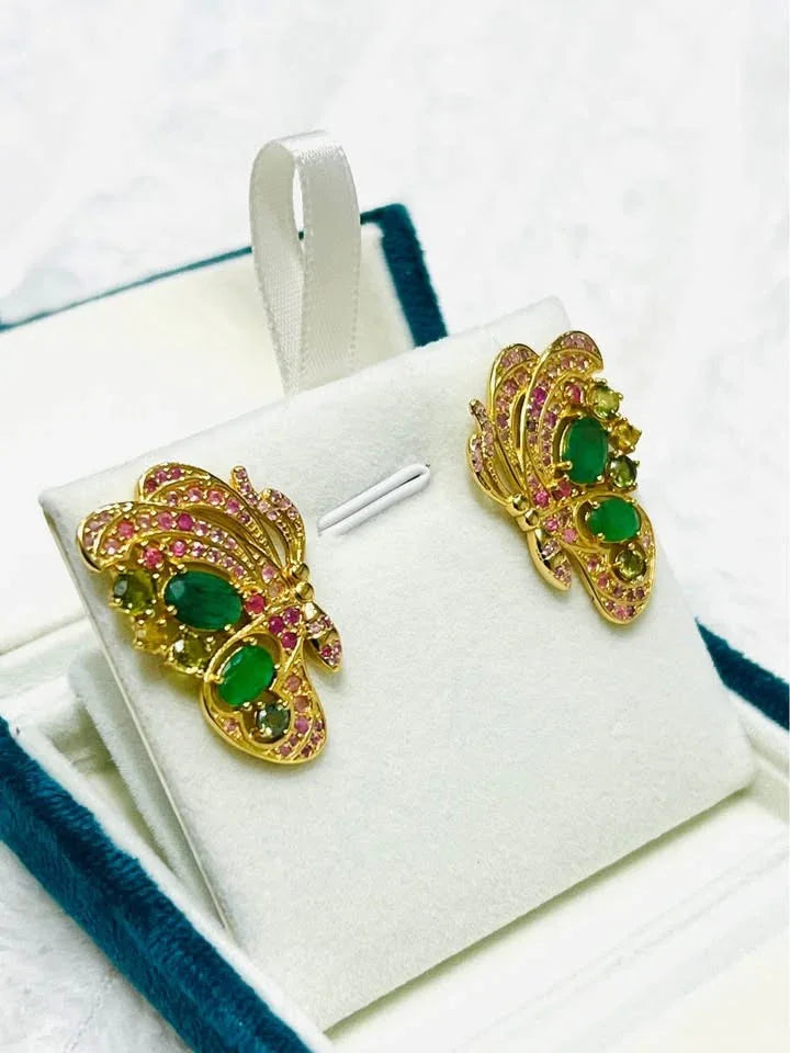 Gold butterfly earrings with Colombian emeralds and assorted sapphires, capturing a vibrant, elegant style.