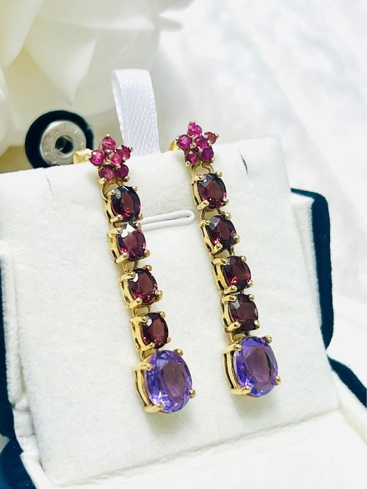 Detailed close-up of David Y designer earrings with amethyst and rhodolite in a display box.