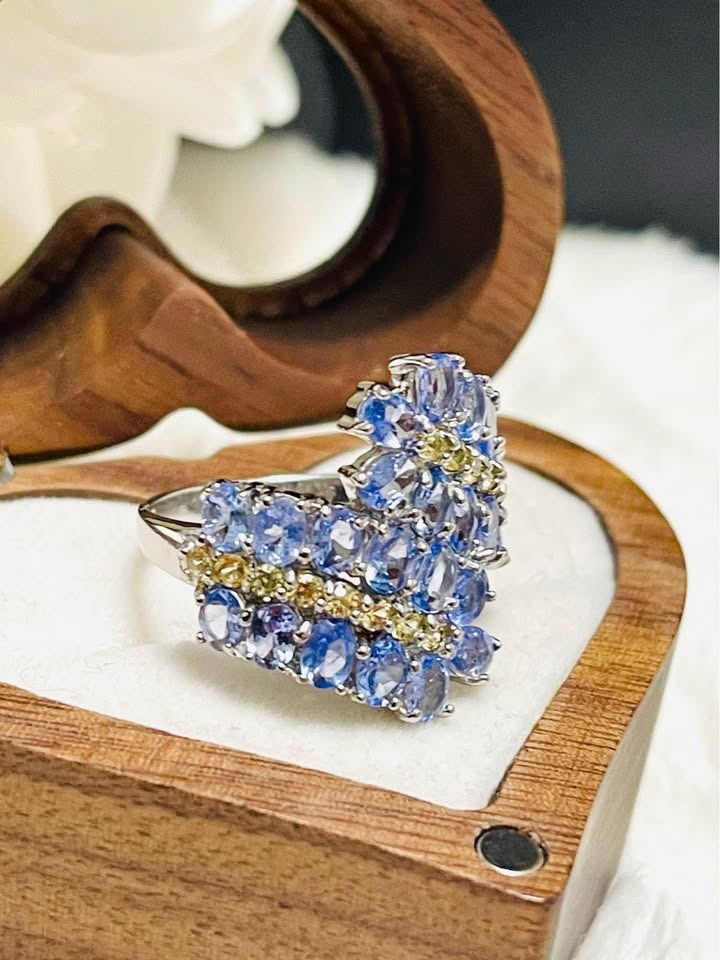 Close-up detail of a sterling silver ring with beautiful tanzanite and yellow sapphire stones in a unique cluster.