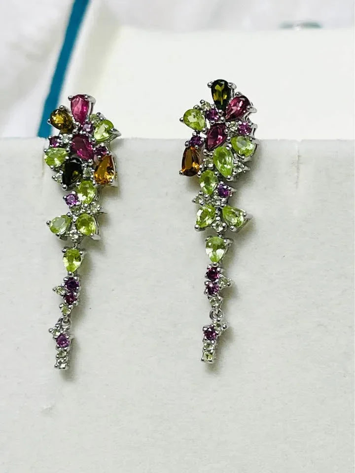 Elegant cluster earrings handcrafted with peridot, rhodolite garnet, citrine, and sapphire on a white background.