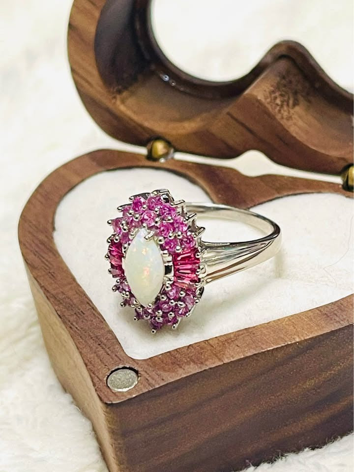 Elegant Australian opal and pink sapphire ring, with a split shank band, in a decorative wooden box.