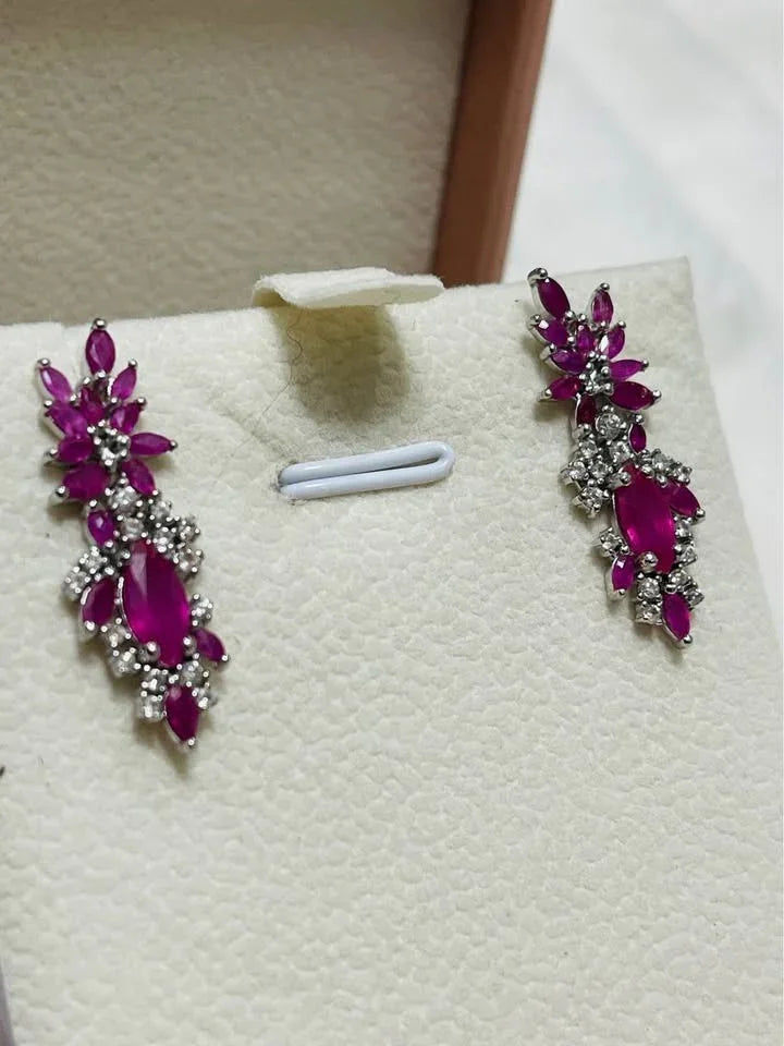 Pair of elegant pink ruby and diamond earrings in a jewelry box. Perfect for special occasions.