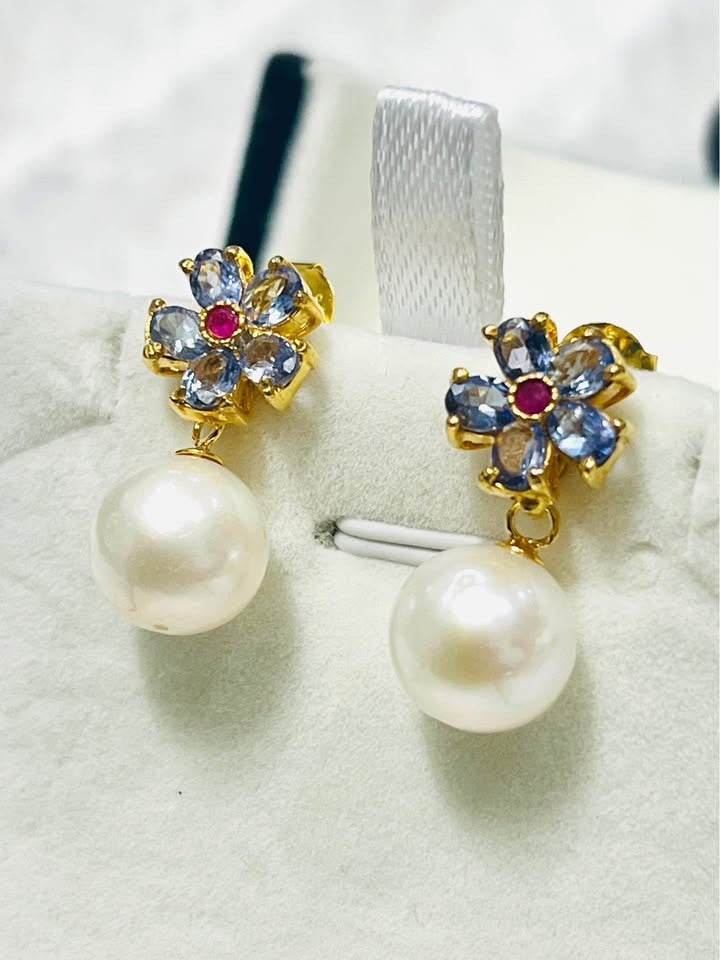  Elegant natural tanzanite, ruby, and South Sea pearl earrings in a close-up display.
