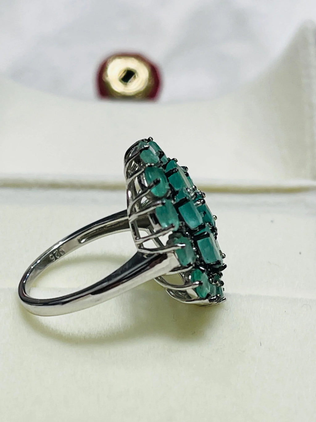 Back view of the emerald and diamond cluster ring, showing the intricate silverwork under the gemstone setting.