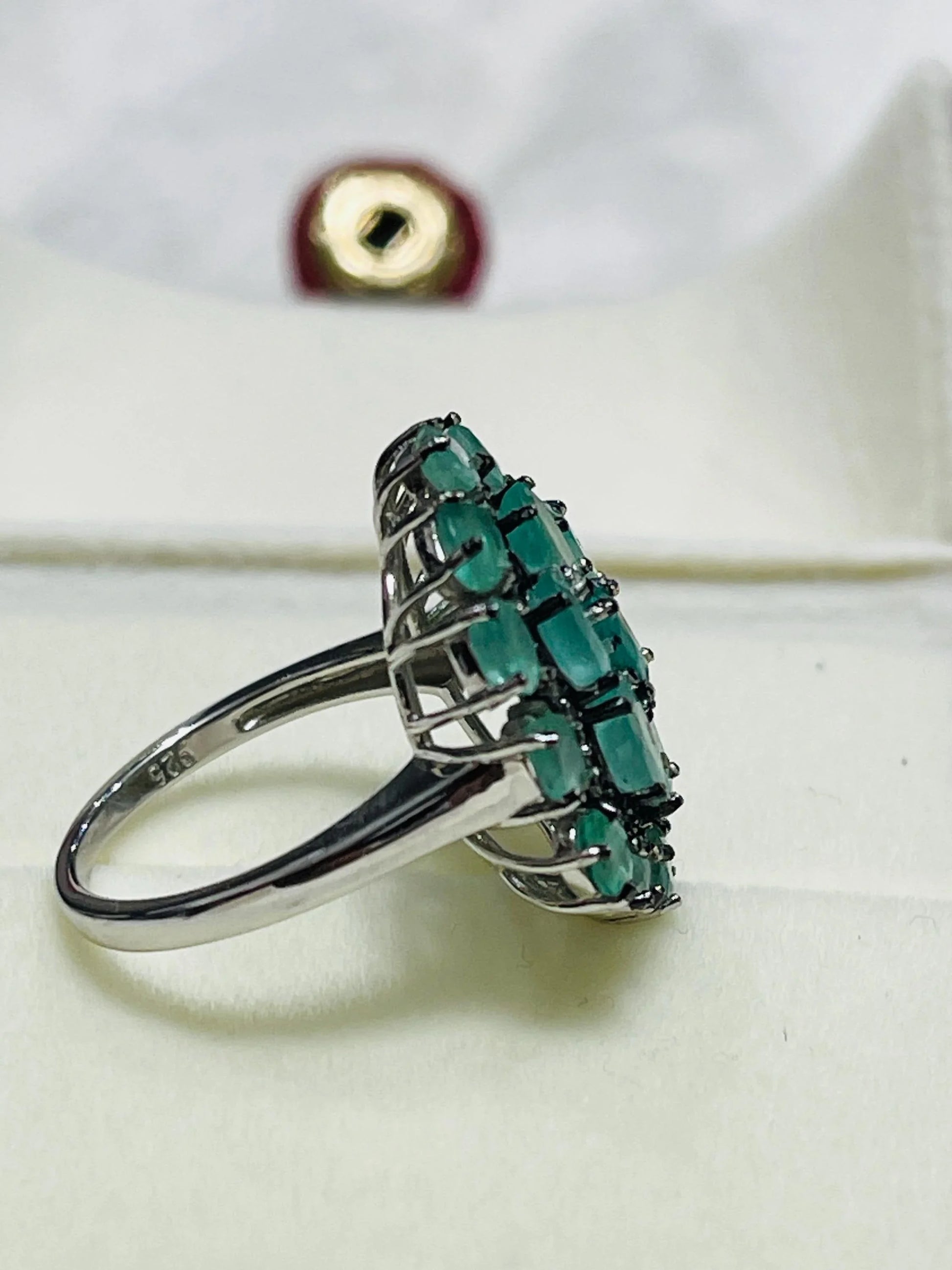 Back view of the emerald and diamond cluster ring, showing the intricate silverwork under the gemstone setting.