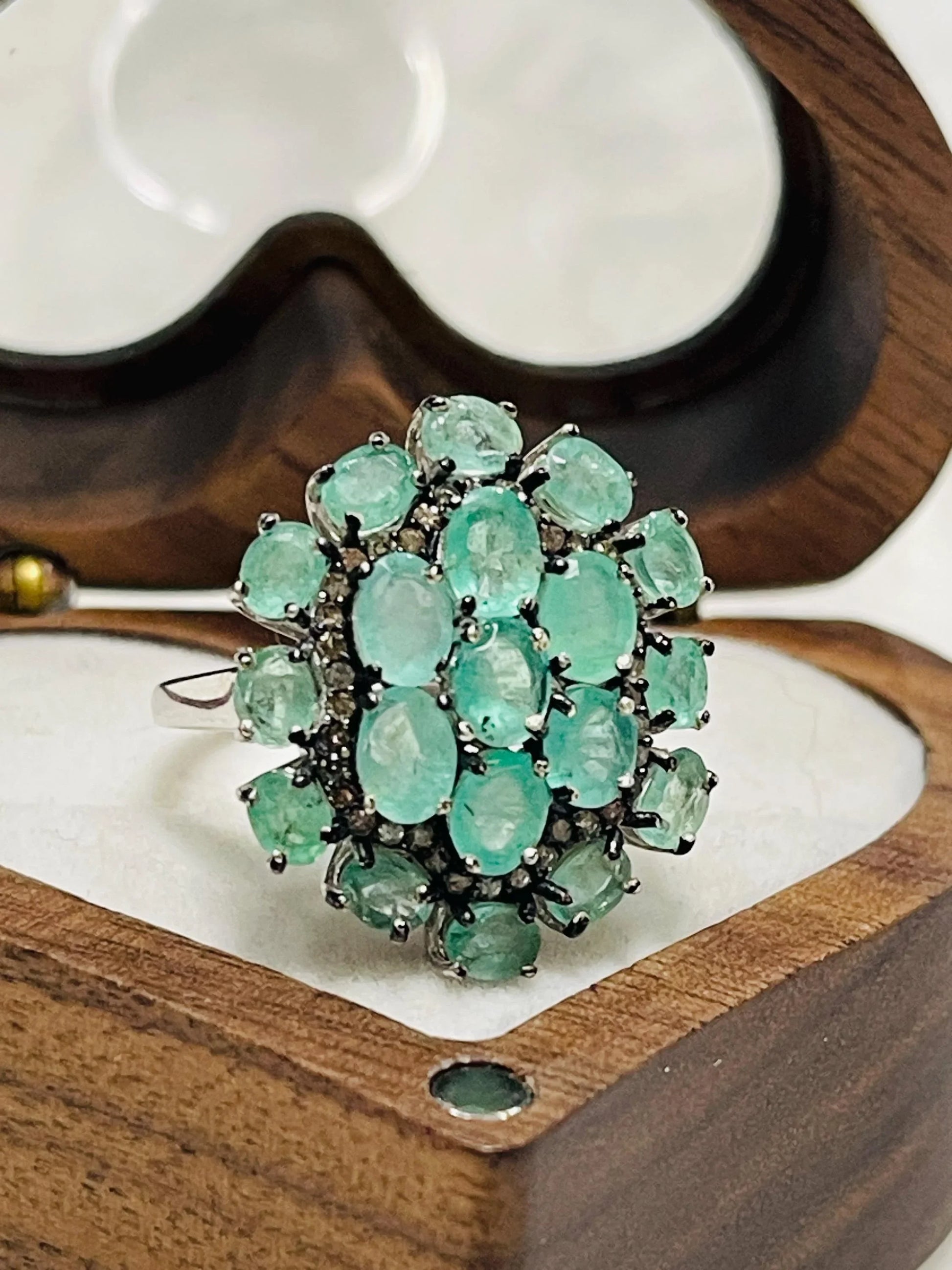  Close-up showing the .925 sterling silver hallmark on the band of the emerald and diamond cluster ring.
