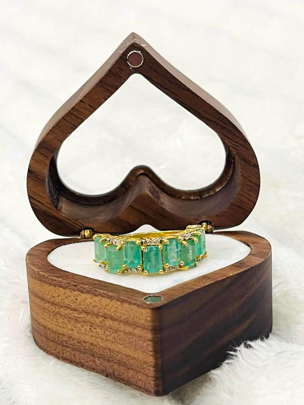  Luxurious emerald and diamond flower ring worn on a finger, displaying its beauty and fit for everyday elegance.