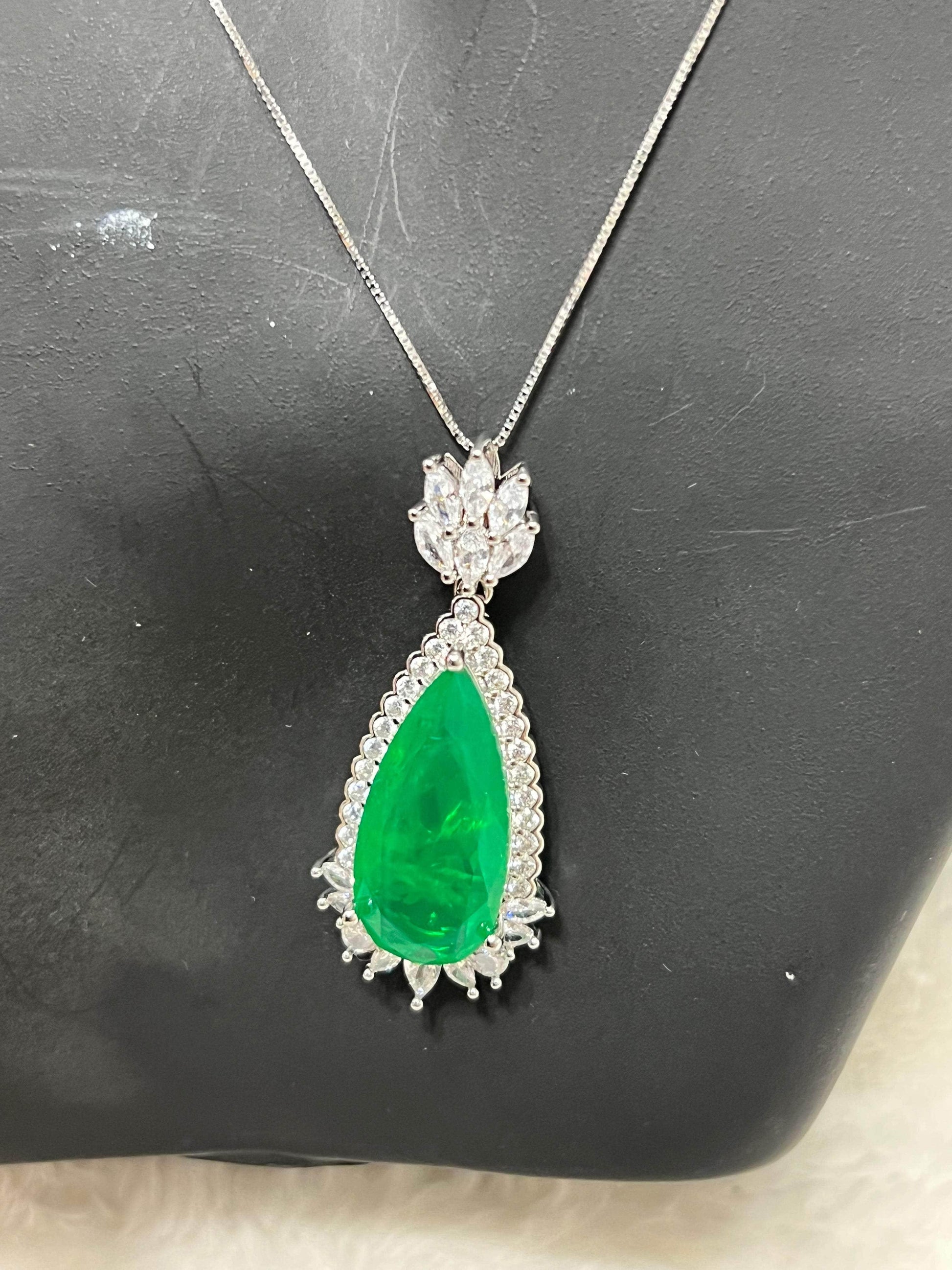 Detailed shot of an emerald doublet pendant with a lustrous green gemstone, set on a delicate silver chain.