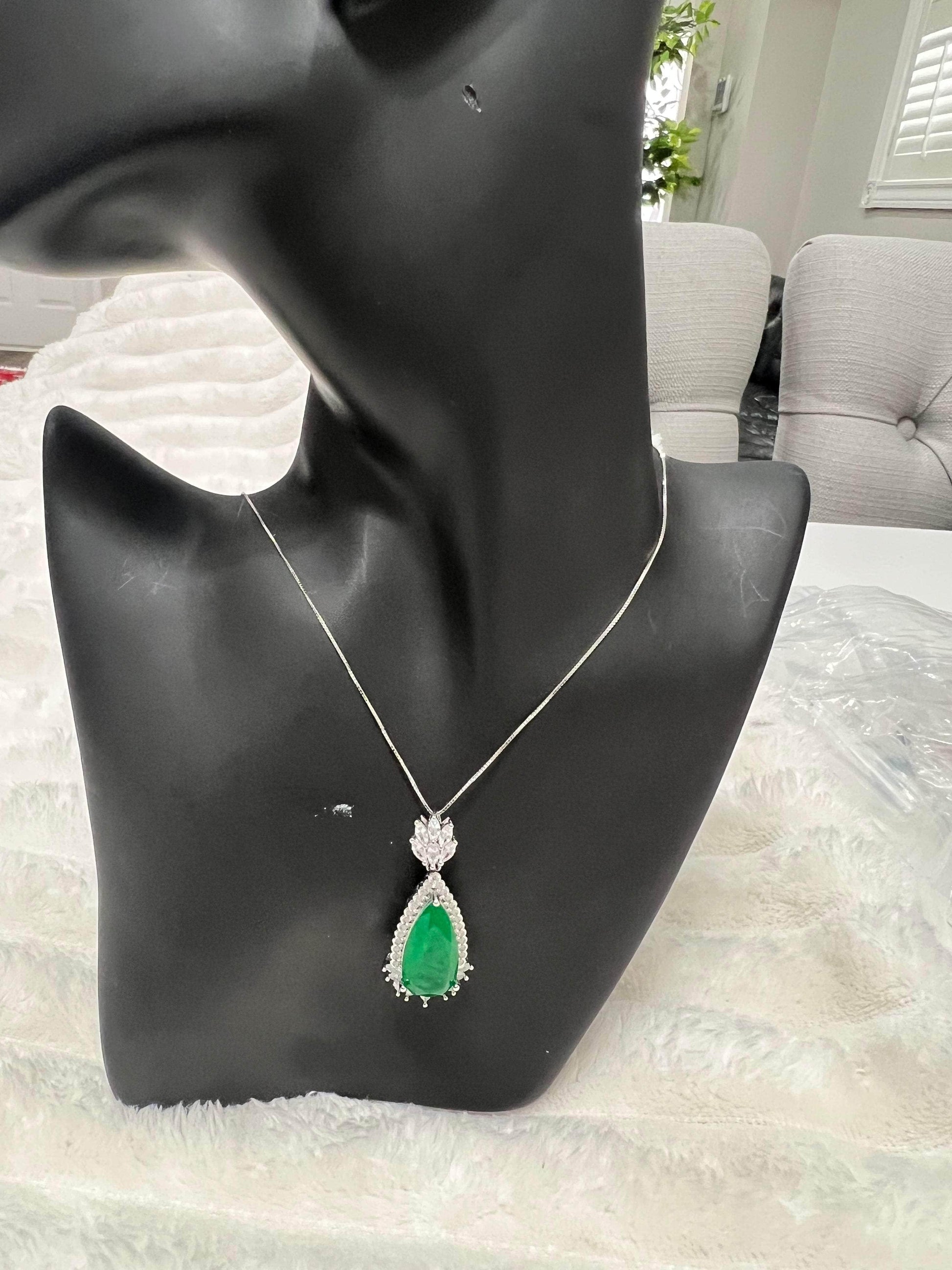 Full view of an elegant emerald doublet pendant on a black mannequin, showcasing its overall design and scale.