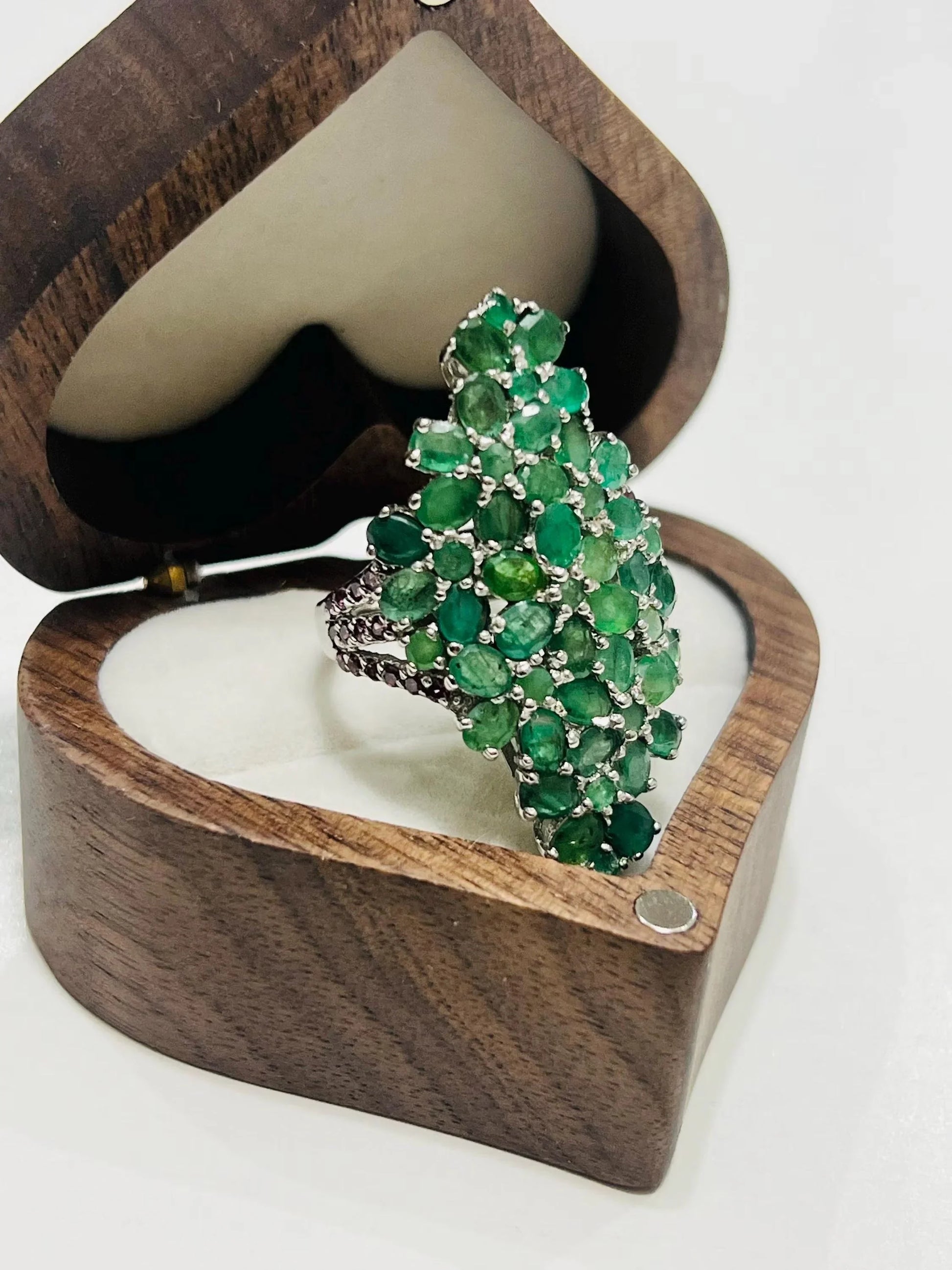 Side profile of the emerald and rhodolite bouquet ring, highlighting the detailed silver band and stone setting.