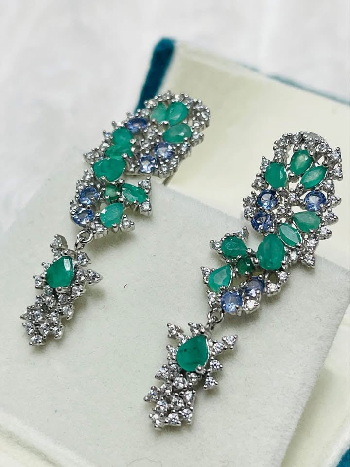  Fancy sterling silver earrings featuring natural emerald and tanzanite gemstones in a beautiful dangle design.