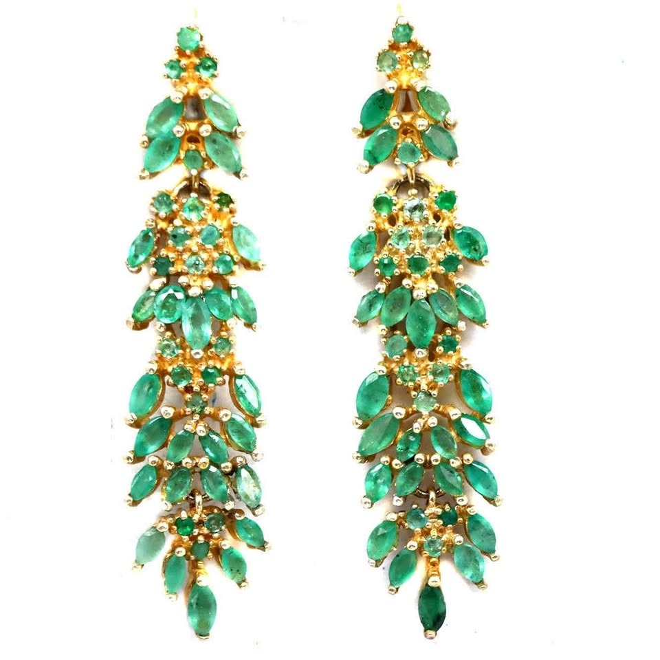 A pair of luxurious fancy dangle earrings with numerous natural Colombian emeralds in a marquise cut.