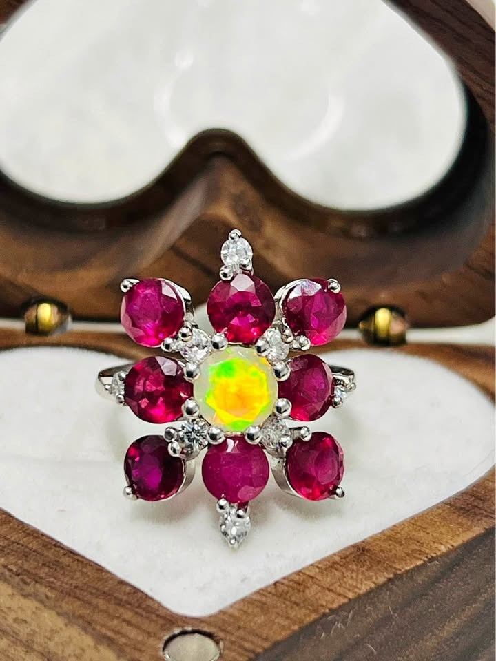  A close-up view of a natural fire opal and ruby ring, highlighting the beautiful colors and intricate details.