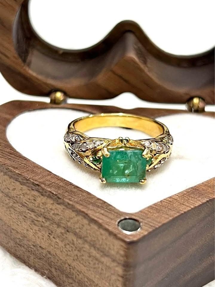  Genuine Colombian emerald and diamond ring in a rich gold setting, front view.