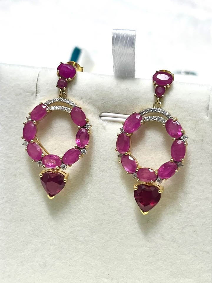Exquisite 10 carat genuine ruby earrings in an Italian design, featuring a circle of rubies with diamond accents.
