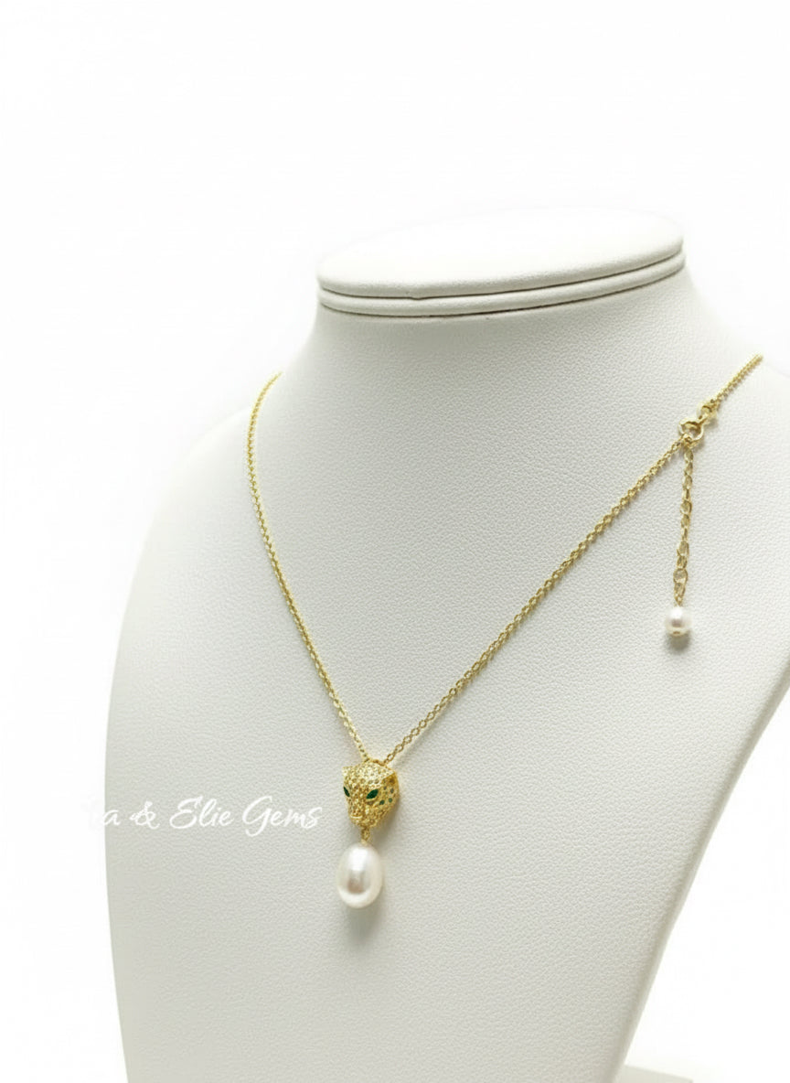 Gold panther necklace with emerald eyes and South Sea pearl worn on a black mannequin.