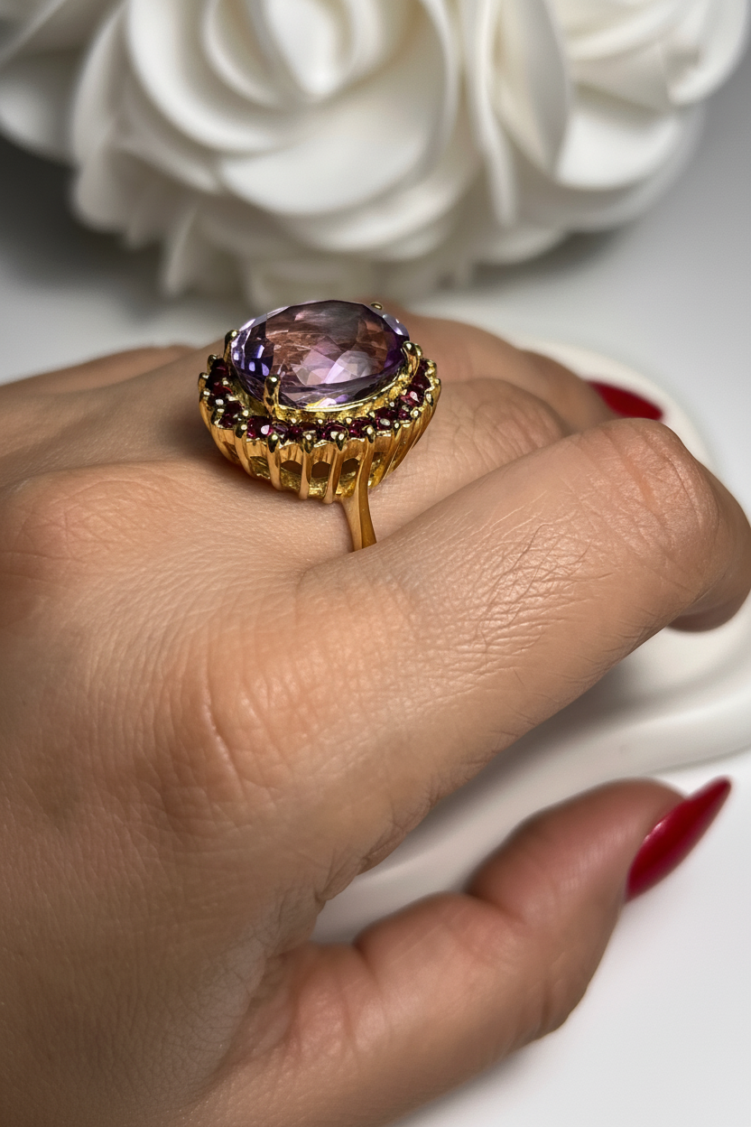 Hand with purple amethyst ring and long red nails