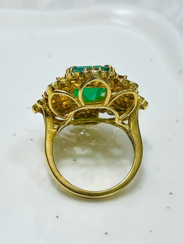 Side and band view of a gold ring with a large emerald cut agate, surrounded by sapphires and diopside.