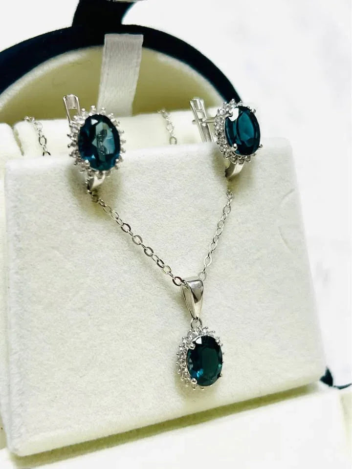Natural London blue topaz oval gemstone jewelry set with halo design in sterling silver.