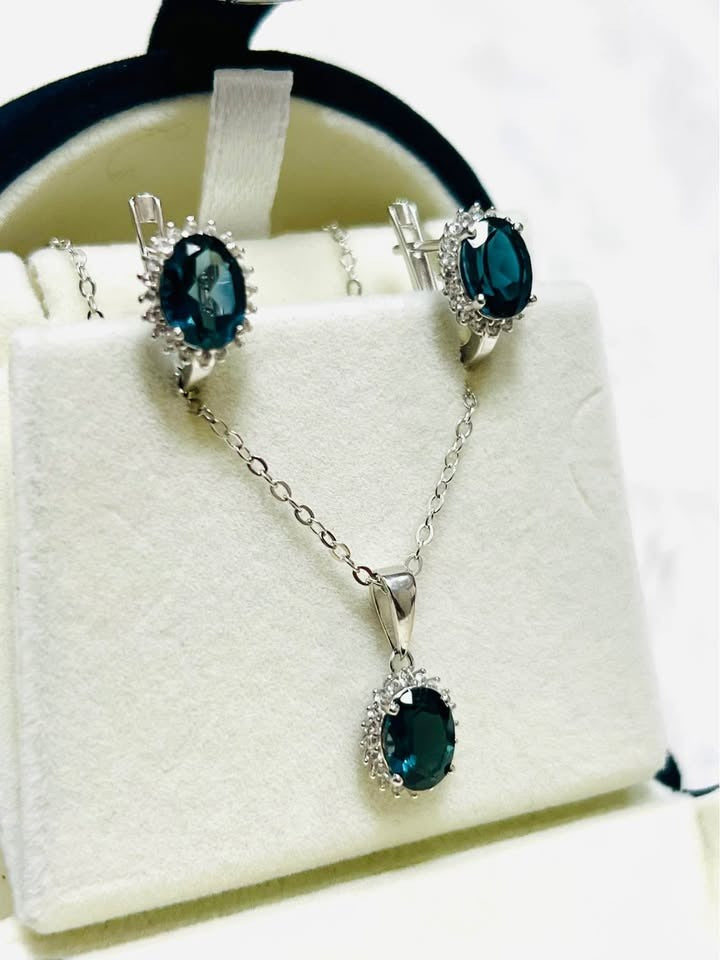 Natural London blue topaz oval gemstone jewelry set with halo design in sterling silver.
