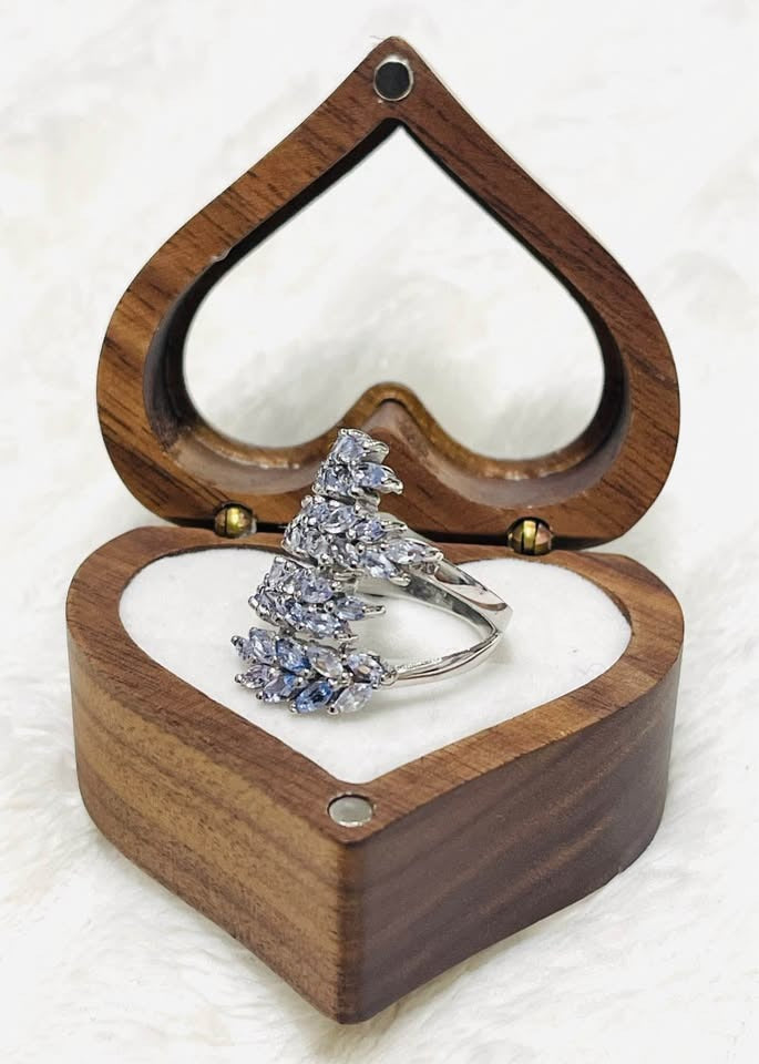 Side angle of a unique marquise tanzanite sterling silver cluster ring, in a heart-shaped display.