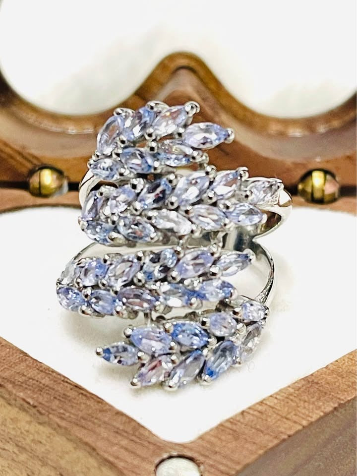 Top view of a sterling silver ring featuring a cluster of marquise-cut natural tanzanite gemstones.