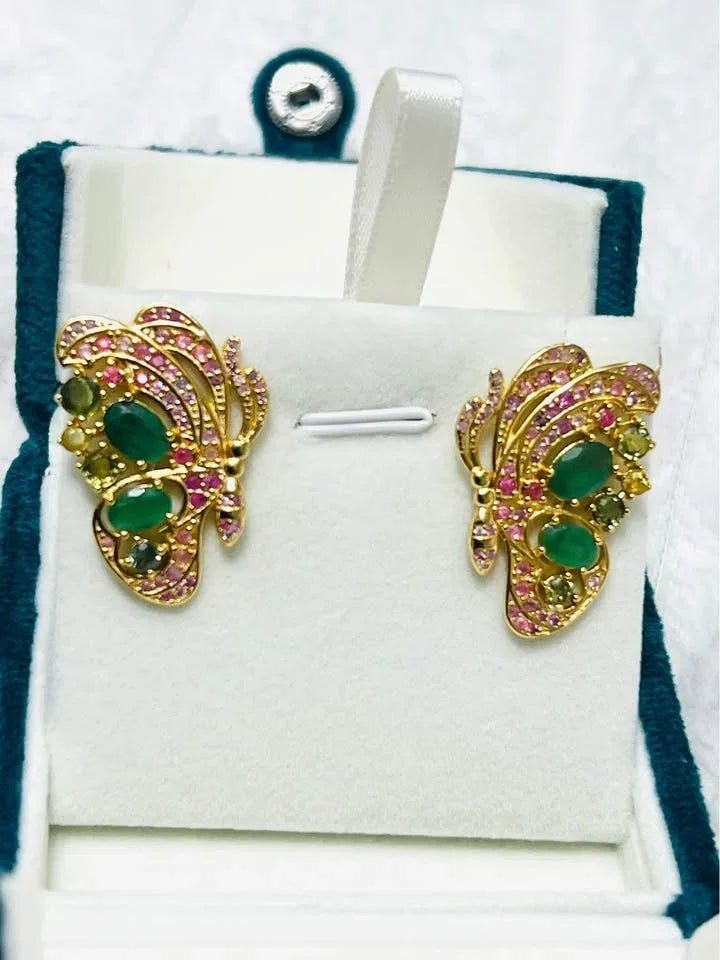 Butterfly earrings featuring multi-color sapphires and vibrant Colombian emeralds in a gold setting.