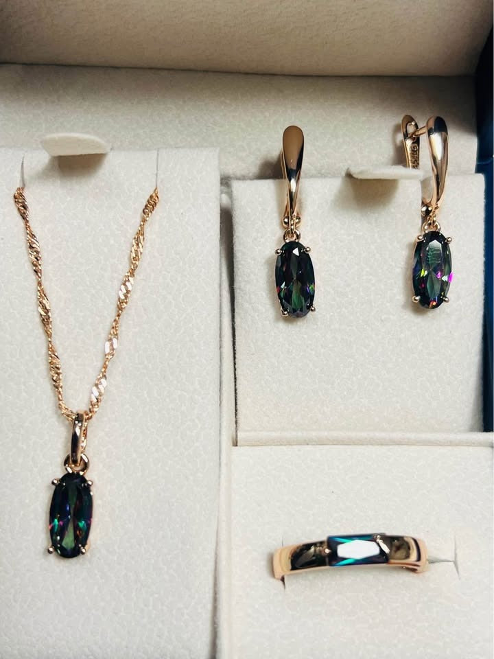 Overhead view of 14k rose gold mystic topaz necklace, earrings, and ring jewelry set.