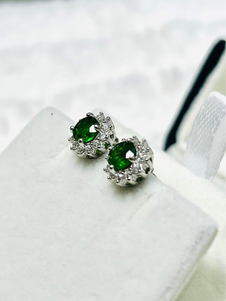 Close-up of natural chrome diopside stud earrings with a sparkling halo setting.