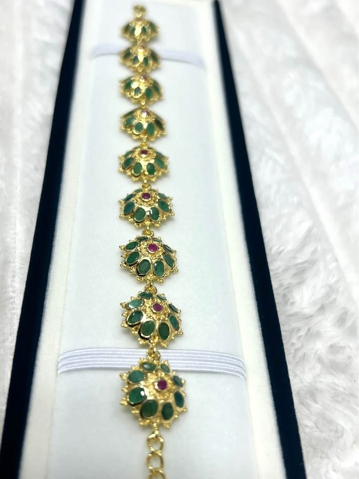 Stunning natural Colombian emerald and ruby bracelet in a jewelry box. Gold floral design.