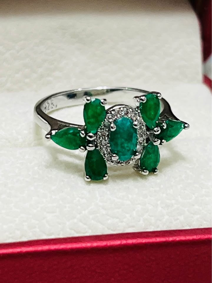 Side view of a natural emerald cluster ring in sterling silver, showcasing its intricate floral arrangement.