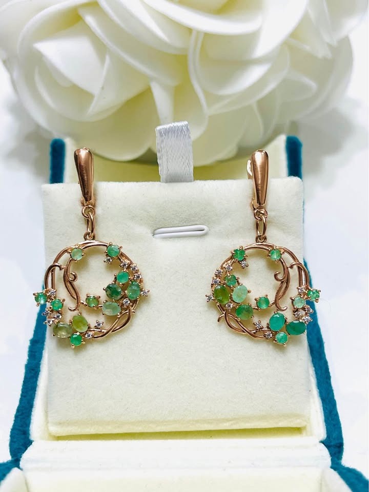 Angled view of natural emerald sterling silver hula hoop earrings, highlighting gemstone sparkle.