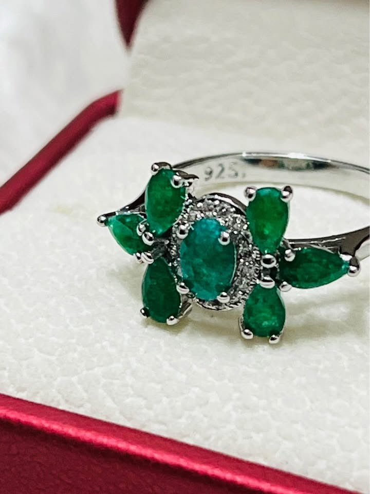  Close-up of a natural emerald sterling silver ring, highlighting the vibrant green stones and the 925 hallmark.