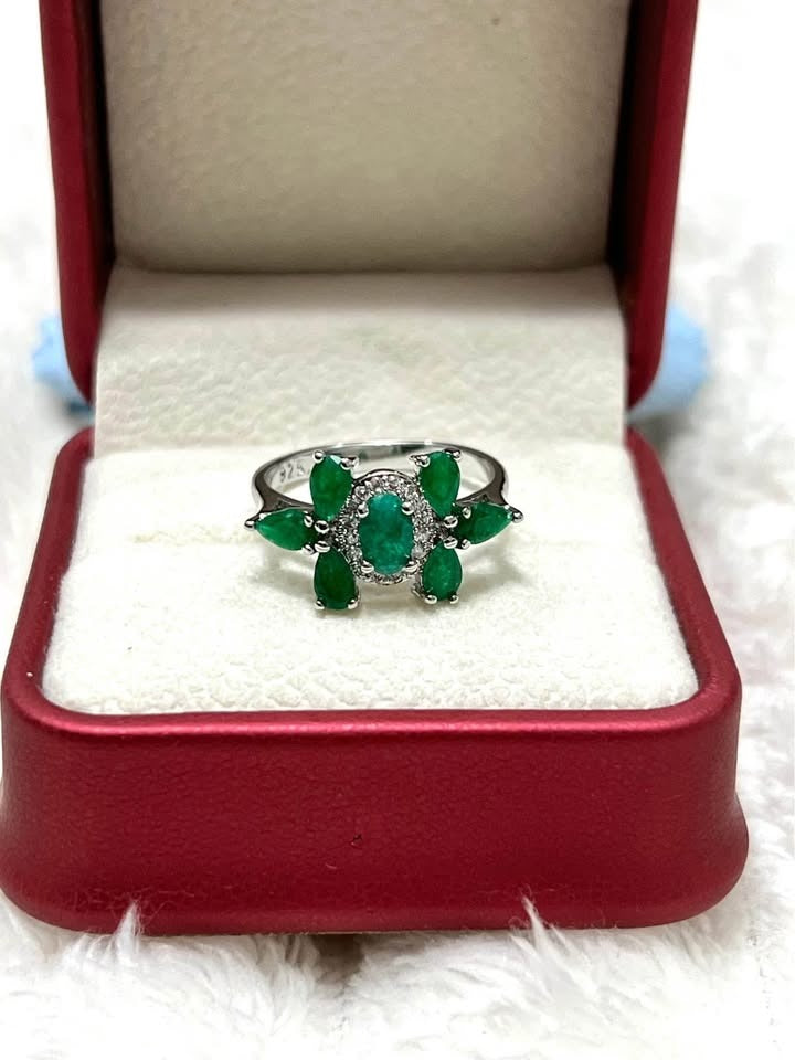 Elegant natural emerald sterling silver ring with a floral design, presented in a vibrant red gift box.