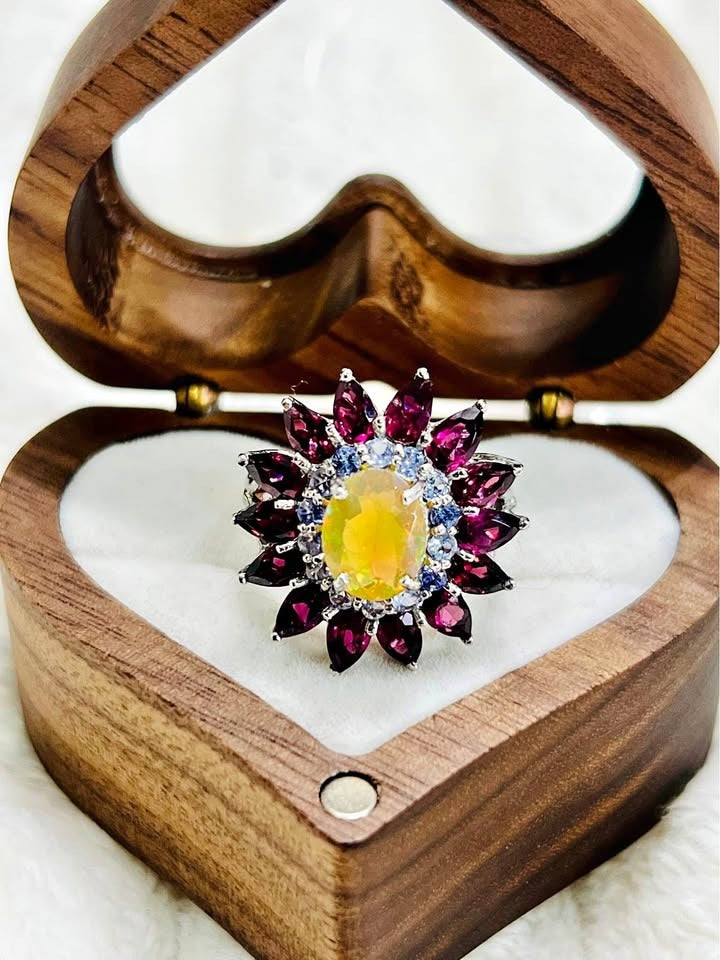 This striking 925 silver ring features a vibrant fire opal, surrounded by marquise-cut rubellites and tanzanites.