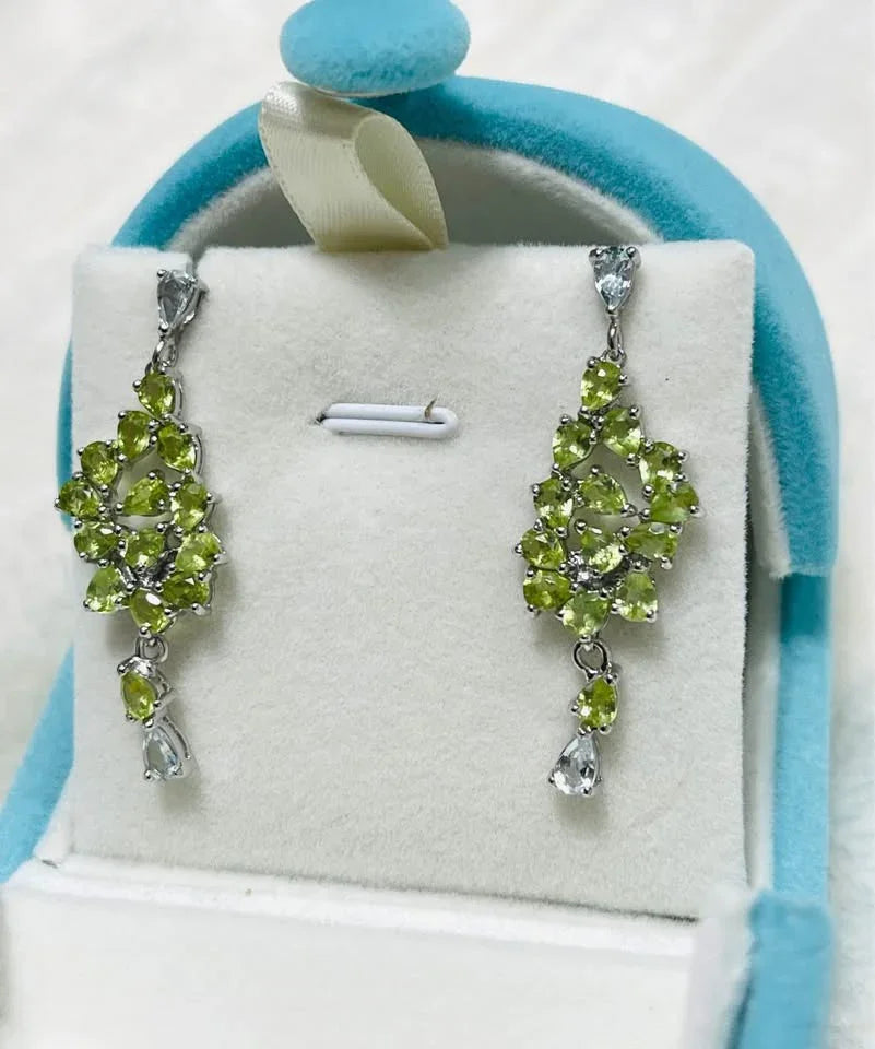 Stunning natural peridot and aquamarine dangle earrings with a floral cluster design, displayed in a blue jewelry box.