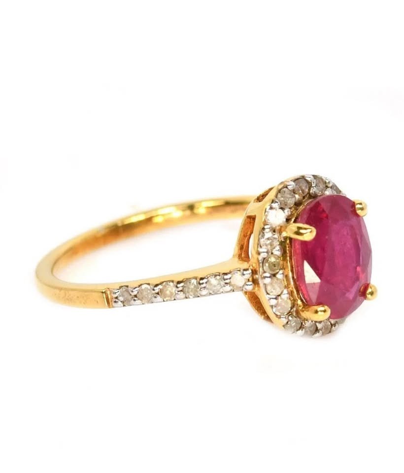  Side profile of a natural ruby and natural diamond halo ring on a gold band.