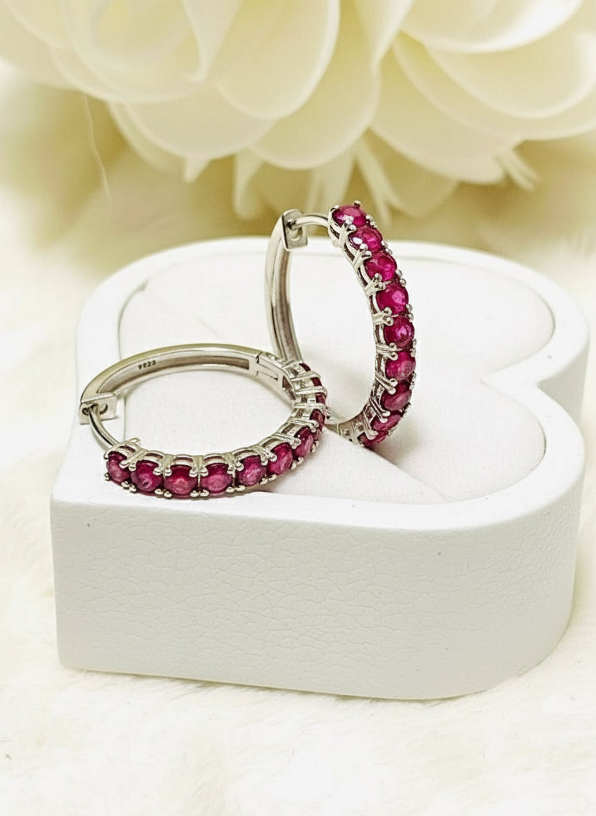 Pair of natural ruby sterling silver hoop earrings displayed in a heart-shaped wooden box.