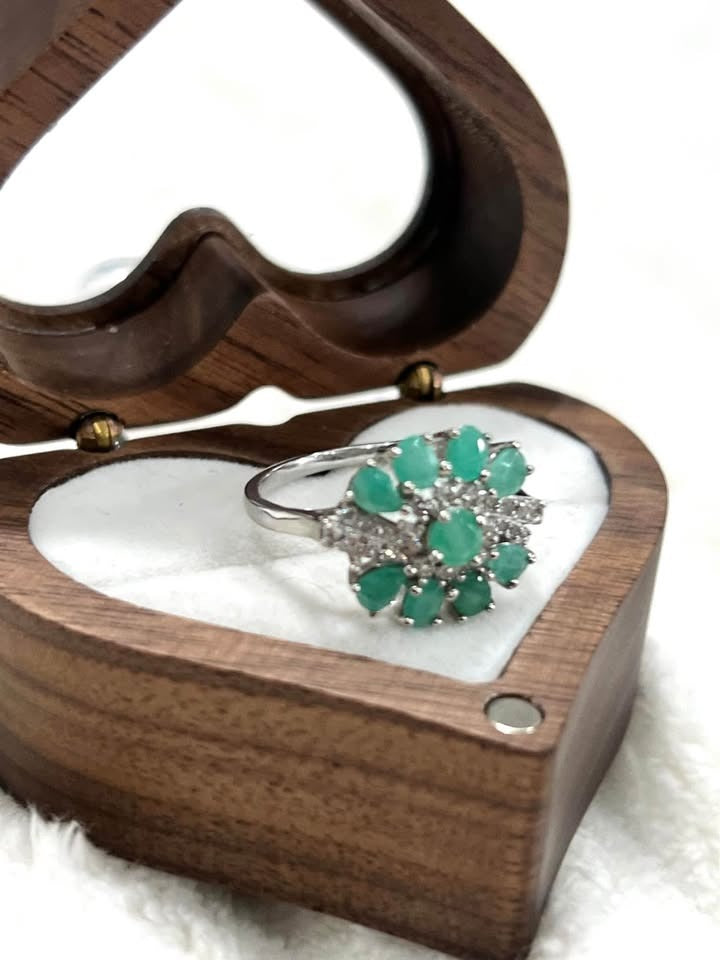 Natural Colombian emerald ring in sterling silver, featuring a flower design in a heart-shaped box.