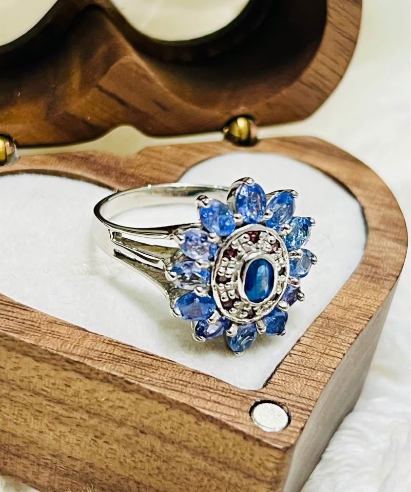 A close-up of a natural sterling silver tanzanite ring featuring a cluster of beautiful blue gemstones.