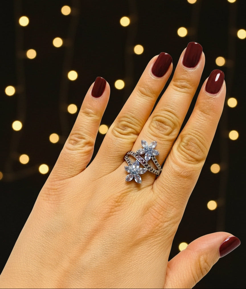 A unique 925 silver ring with tanzanite and rhodolite, modeled on a hand to show the scale and fit.