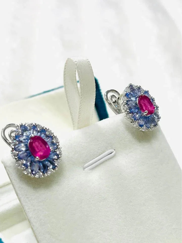 Natural tanzanite and ruby sterling silver earrings, beautifully displayed in a white and teal velvet jewelry box.