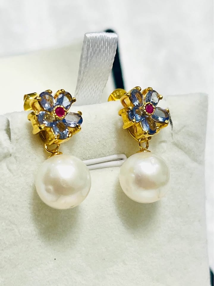 Exquisite natural tanzanite, ruby, and South Sea pearl dangle earrings in gold setting.